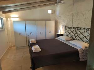 a bedroom with a black bed with white pillows at La Fragna in Nardò