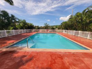 Spanish TownComfortable Strategic Lodging Quarters的一个带白色围栏的大型游泳池