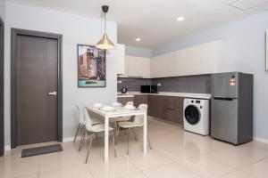 cocina con mesa blanca, sillas y lavavajillas en High Floor Suasana Suites 5 in JB City with WiFi, en Johor Bahru