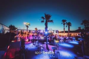 a party with palm trees and lights at night at T2 Marseille Plage in Marseille