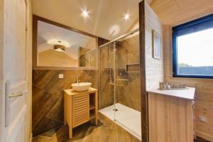 une salle de bain avec un lavabo et une douche dans l'établissement Le chalet aux portes du pays d Auge, à Saint-Samson