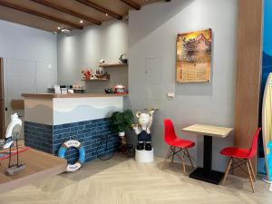 un ristorante con due sedie rosse e un tavolo di 洄游民宿 Migration B&B a Donggang