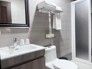 un bagno bianco con lavandino e WC di 洄游民宿 Migration B&B a Donggang Altre 37 foto
