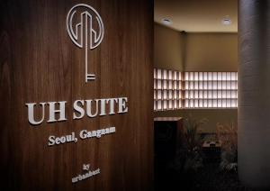 a sign on a wall with a us unite sign on it at UH Suite The Gangnam in Seoul