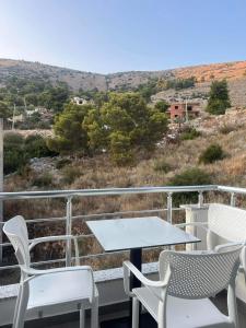 a table and chairs on a balcony with a view at Nōya Suites SR in Sarandë