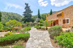a garden with a stone path leading to a house at Finca Especial El Pino en Esporles in Esporles