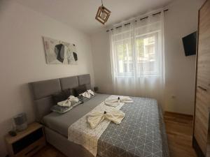 a bedroom with a bed with a bow on it at Apartman Pavlović in Soko Banja +12 photos