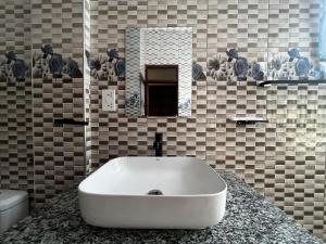 a bathroom with a white sink on a counter at Gavril's Bed and Breakfast in Arusha +18 photos