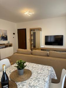 a living room with a couch and a table with a bottle of wine at Iris home in Favaro Veneto +10 photos