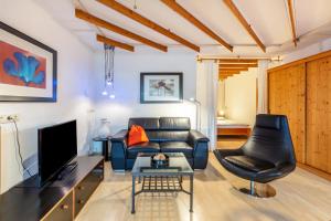 Una sala de estar con un sofá y un televisor. en Gästehaus Helga Scherer, en Ballrechten