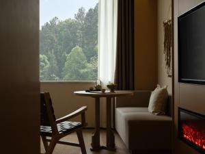 a living room with a table and a window at Yanyu Yunxi Resort Hotel 烟雨云兮酒店 in Fenghuang County