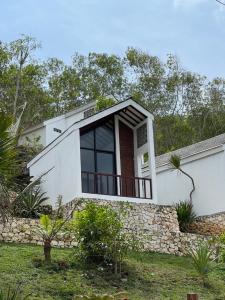 a white house with a large window and a stone wall at Naradhipta in Baron