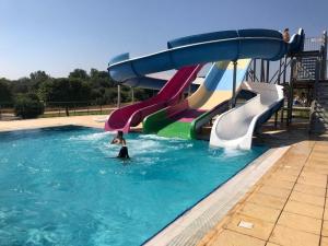 a person riding a water slide in a swimming pool at Thalassa Beach Resort in Vokolidha