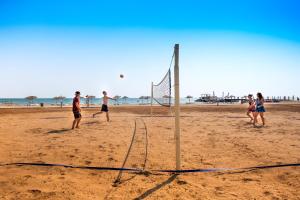 a group of people playing a game of volleyball on the beach at Thalassa Beach Resort in Vokolidha +16 photos