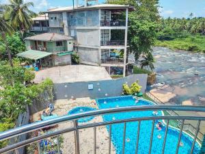 a resort with a swimming pool next to a river at Hotel Elephant Park - Most Elephant Bathing View Rooms in Pinnawala in Pinnawala