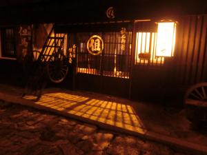 a gate to a house at night with a light at Tajimaya in Nakatsugawa