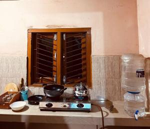 a kitchen counter with a stove and a window at The Green Hills in Guwahati +26 photos