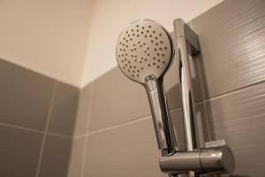 a shower head attached to a wall in a bathroom at Comfort 15H in Dunajská Streda +28 photos
