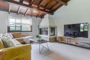 a living room with a couch and a fireplace at Elysian Villa in Miño