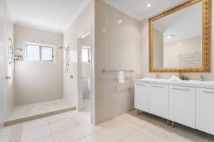 a bathroom with a shower and a sink and a mirror at Spyglass Mollymook in Mollymook +32 photos
