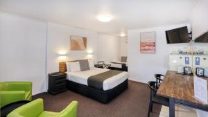 a hotel room with a bed and a table and chairs at Best Western Caboolture Gateway Motel in Caboolture +32 photos