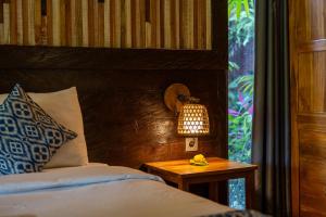 Un dormitorio con una cama y una mesa con una lámpara. en Parvati Retreat Villas, en Ubud 136 fotos más
