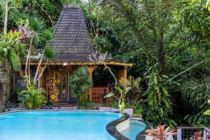 una piscina frente a una casa en Parvati Retreat Villas, en Ubud