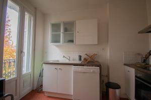 a kitchen with white cabinets and a sink and a window at Nouveau ! T2 lumineux en centre ville in Aix-en-Provence +5 photos