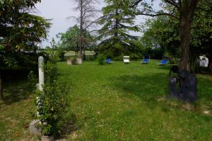 a yard with blue chairs and a tree at B&B Cà d'Artisti in Caorle