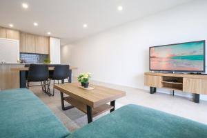 a living room with a large flat screen tv at Stunning 1-Bed Bayside Apartment with Superb Views in Batemans Bay