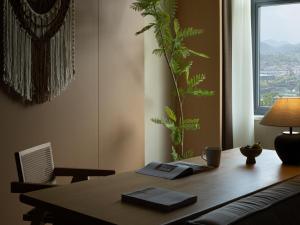 a wooden table with a plant in a room at Yanyu Yunxi Resort Hotel 烟雨云兮酒店 in Fenghuang County