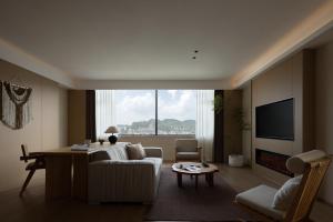 a living room with a white couch and a tv at Yanyu Yunxi Resort Hotel 烟雨云兮酒店 in Fenghuang County