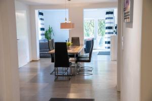 Un comedor con una mesa y sillas negras. en Villa Nordhang - Apartment 4, en Winterberg