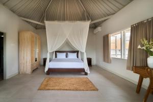 克罗柏坎villa Chamia 2 chambres - proche Umalas的带床和蚊帐的卧室