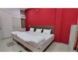 a bed in a room with a red wall at Shree Puram in Varanasi