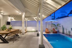 克罗柏坎villa Chamia 2 chambres - proche Umalas的一个带桌子的室内游泳池和一间餐厅