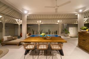 克罗柏坎villa Chamia 2 chambres - proche Umalas的配有木桌椅的餐厅