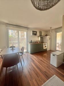 a living room with a table and a kitchen at La PASSERELLE in Toulouse +12 photos