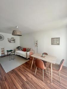a living room with a table and a couch at La PASSERELLE in Toulouse