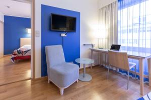 a room with a desk and a table with a chair at Scandic Hämeenlinna City in Hämeenlinna