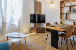 un salon avec une table et une télévision dans l'établissement Le Relax - Maison climatisée avec terrasse - Troyes, à Troyes