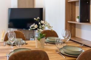 une table avec des assiettes et des verres et un vase avec des fleurs dans l'établissement Le Relax - Maison climatisée avec terrasse - Troyes, à Troyes
