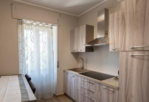 a kitchen with wooden cabinets and a sink and a window at Nella mia città in Lagonegro