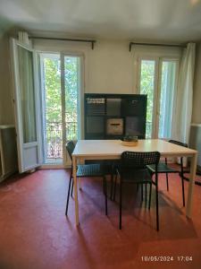 a table and chairs in a room with windows at Nouveau ! T2 lumineux en centre ville in Aix-en-Provence