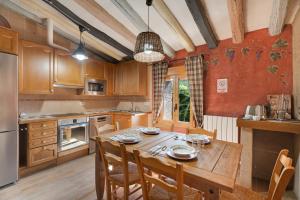 a kitchen with a wooden table with chairs and a dining room at Atalaya in Santa Eulalia la Mayor
