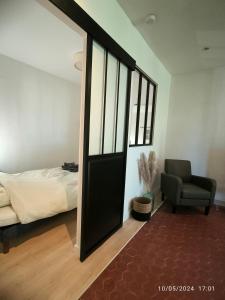 a bedroom with a door leading to a bed and a chair at Nouveau ! T2 lumineux en centre ville in Aix-en-Provence