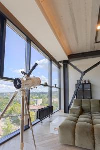a telescope in a living room with a couch at HOUSE38 Panoramic View Apartments SELF CHECK-IN in Kaunas