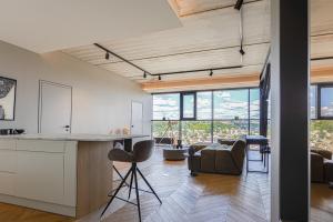 an open kitchen and living room with large windows at HOUSE38 Panoramic View Apartments SELF CHECK-IN in Kaunas