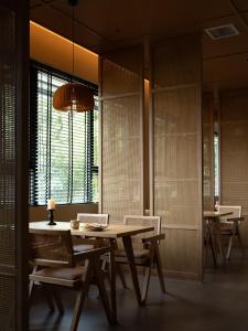 a dining room with a table and chairs and a window at Yanyu Yunxi Resort Hotel 烟雨云兮酒店 in Fenghuang County