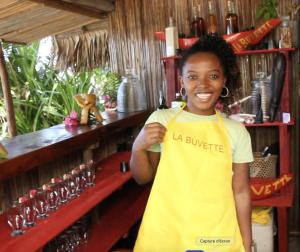 a young girl standing in front of a store at Les Lodges de La Buvette ÉCO LODGE RESTAURANT in Ile aux Nattes